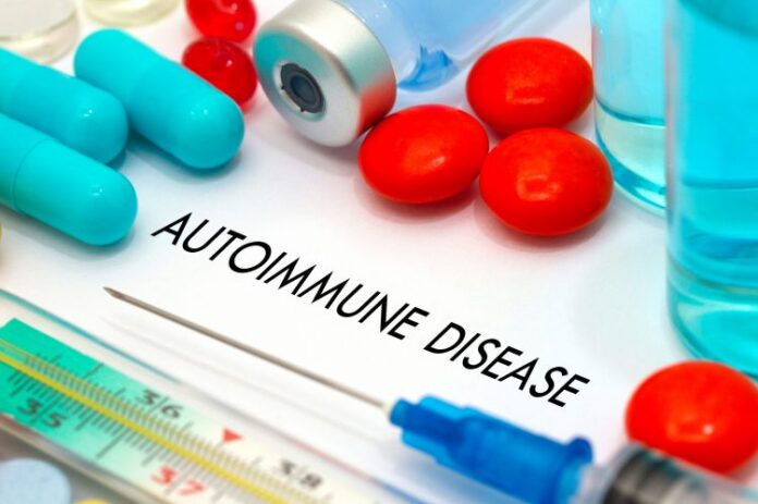 A close-up image of medical supplies and pills with the words 'AUTOIMMUNE DISEASE' written on a white background. The image includes blue and red pills, a syringe, and a medical vial, representing the context of autoimmune disease treatment.